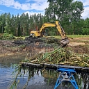 Cleaning a water body with an excavator