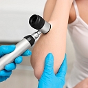 Examination of the skin of the elbow area with a dermatoscope, evaluating skin structure and possible changes.