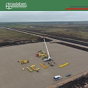 Construction work in a large area, where heavy equipment is deployed and the foundation is prepared for future projects.