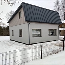 Privātmāja ar metāla jumtu ziemas apstākļos