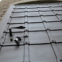 Металлическая дверь с камнями и заклепками для реконструкции водонапорной башни в Вецмилграви