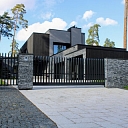 Custom metal fence installation near the house with a modern design