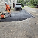 uses a vibrating plate, to compact the asphalt laid on a construction site.