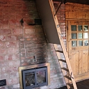 Wooden stairs and fireplace in the interior of a wooden house