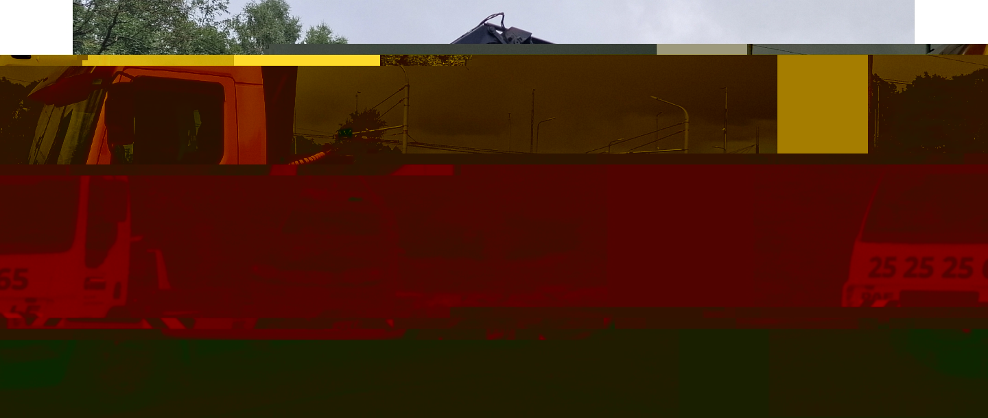 Evakuators, kas paceļ lielu traktoru no lauku teritorijas.