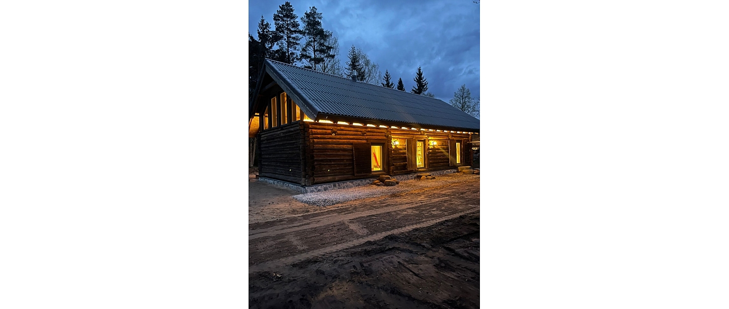 Guļbūves māja vakarā ar apgaismojumu