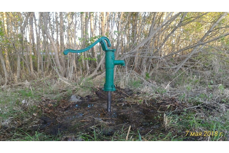 Hand water pump on spice well garden