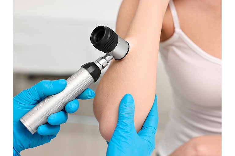 Examination of the skin of the elbow area with a dermatoscope, evaluating skin structure and possible changes.