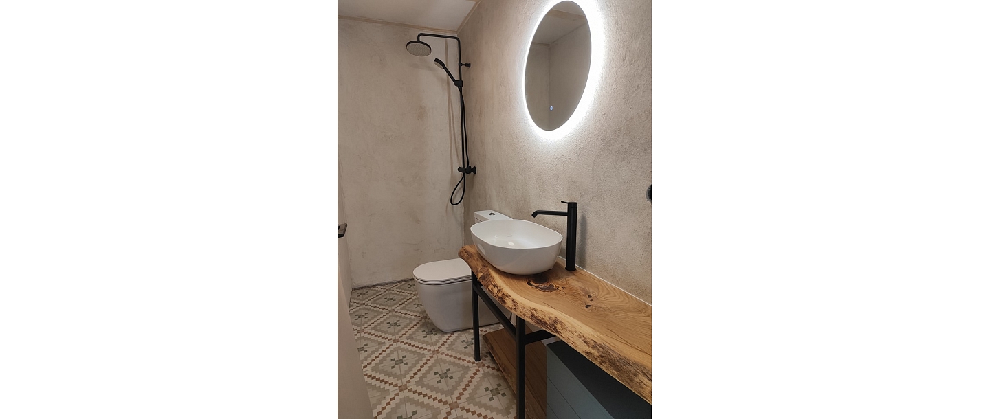 Интерьер ванной комнаты с элементами из дерева и дизайнерской раковиной