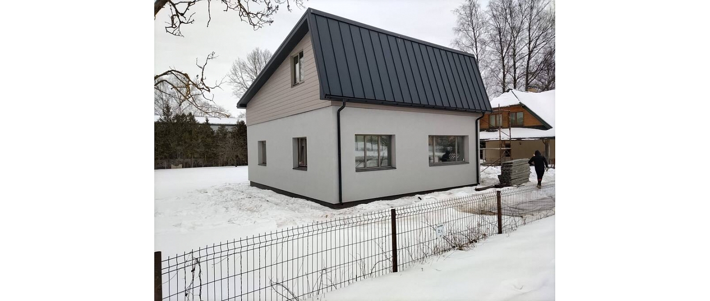 Privātmāja ar metāla jumtu ziemas apstākļos