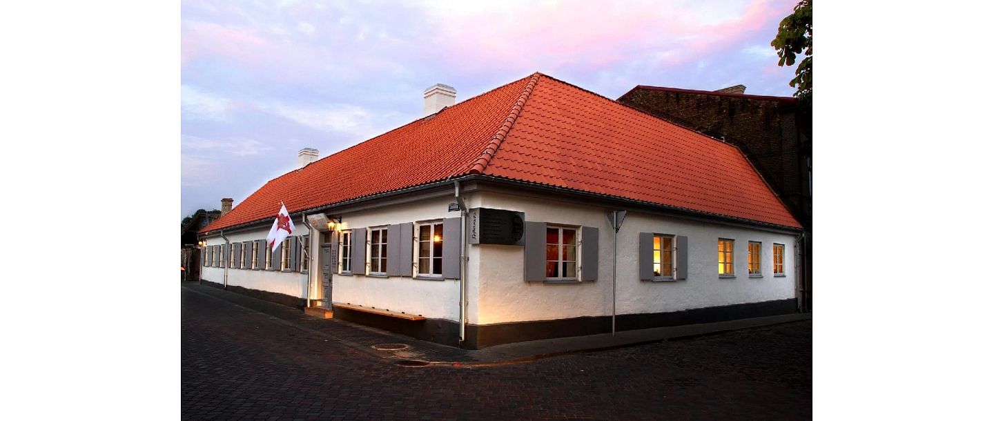 House with white walls and a red roof