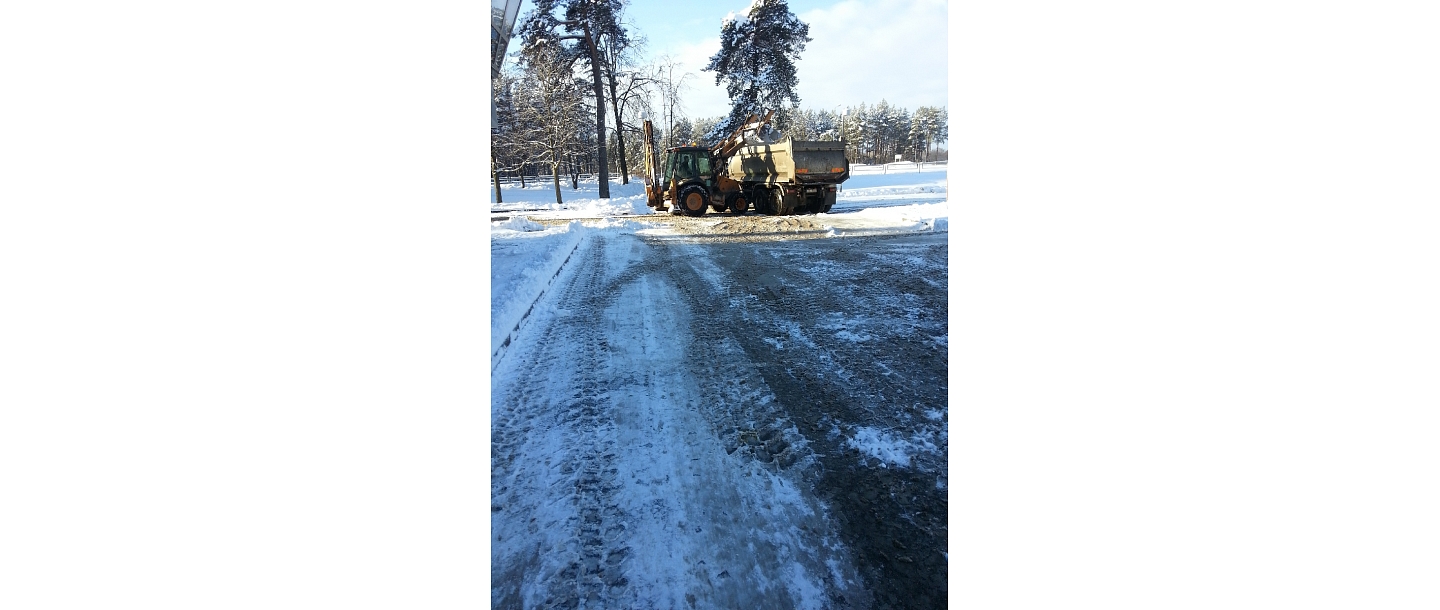 Clearing sidewalk parking lots from snow.