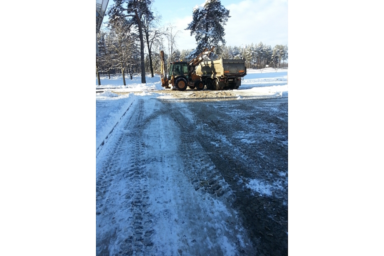 Clearing sidewalk parking lots from snow.