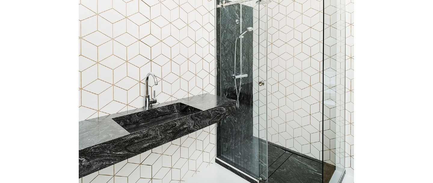 The surface of the bathroom with sink and shower remains with a panel made of Corian ® material