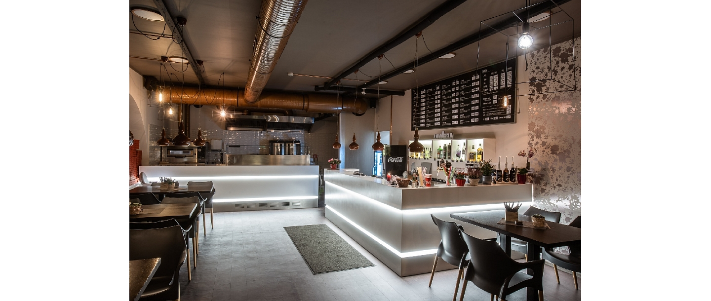 Рабочие столы с подсветкой в пиццерии Ātra pica Kebab из искусственного камня