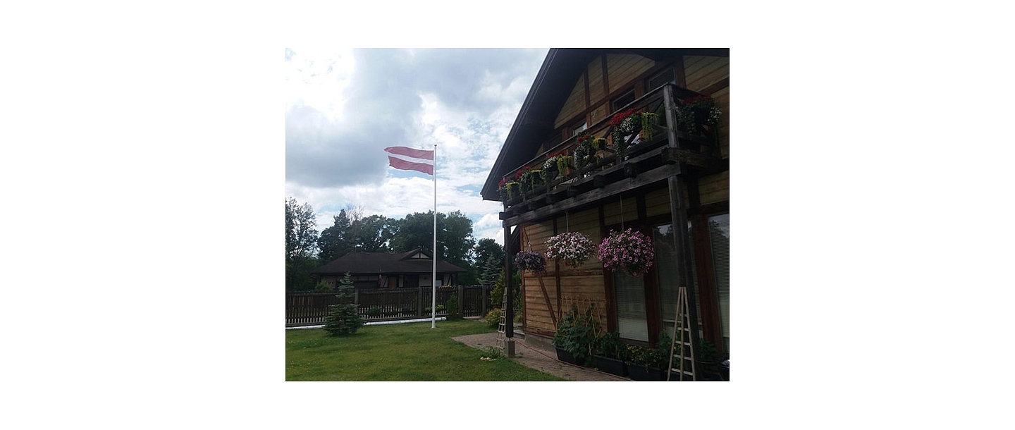 Latvijas karogs privātmājas pagalmā