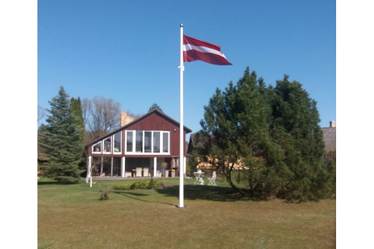 Latvijas karogs privātmājas pagalmā