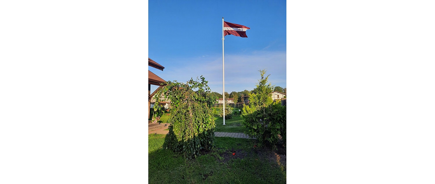 Latvijas karogs privātmājas pagalmā