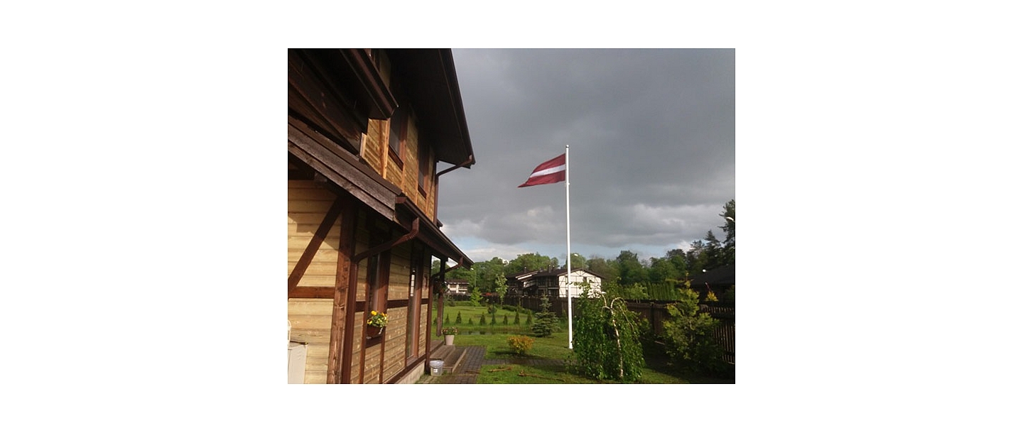 Latvijas karogs privātmājas pagalmā