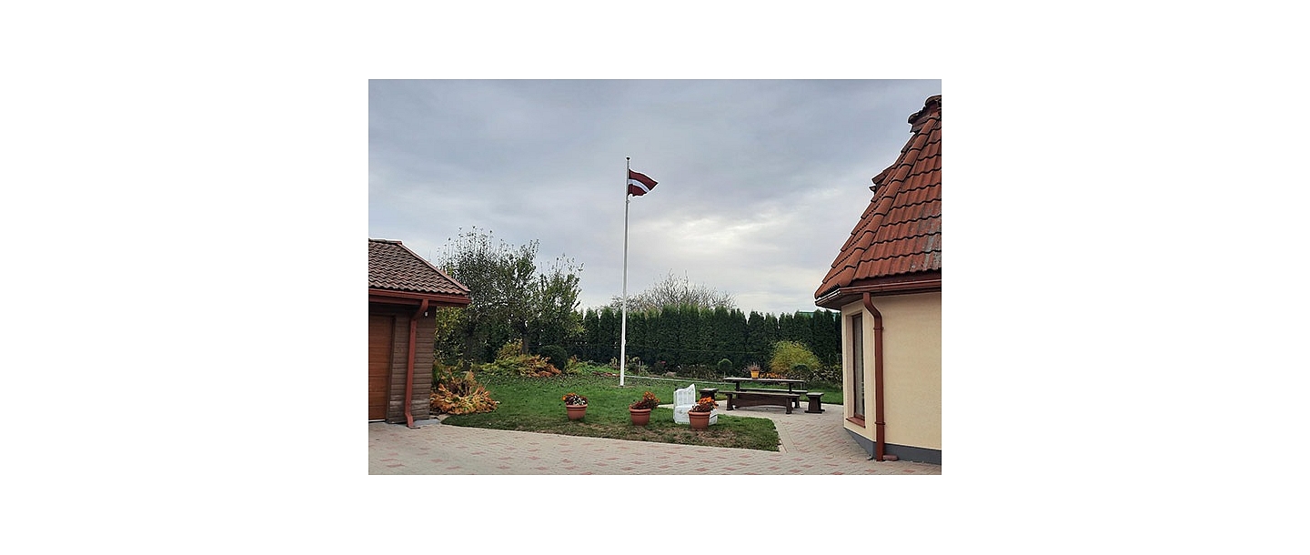 Latvian flag in the yard of a private house