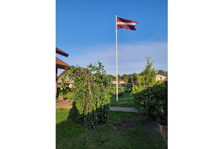 Latvian flag in the yard of a private house