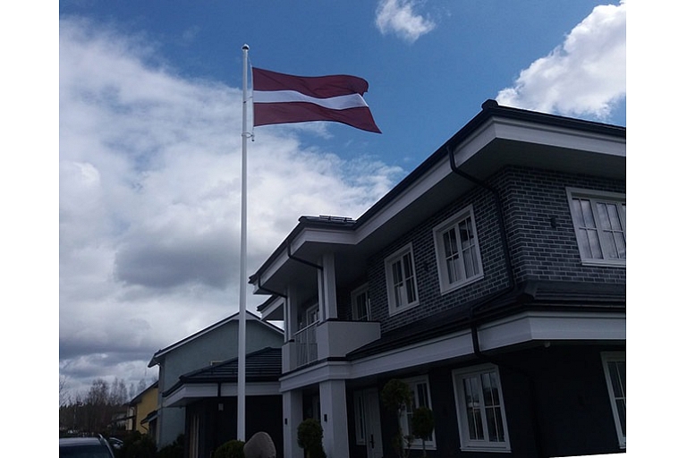 Latvijas karogs privātmājas pagalmā