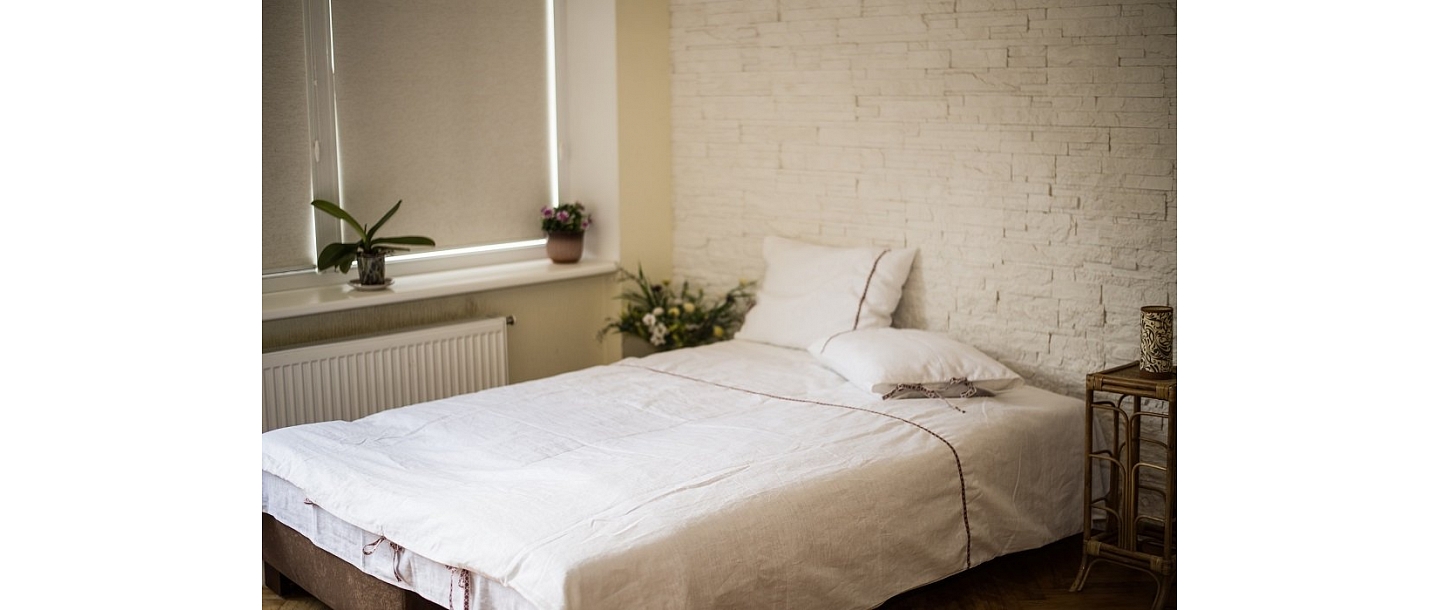 White linen bedding with decorative ribbon – natural comfort for the bedroom