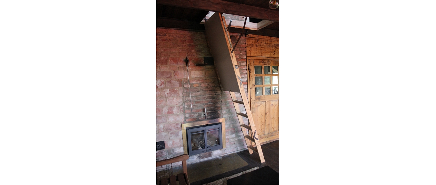 Wooden stairs and fireplace in the interior of a wooden house