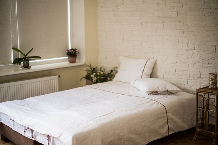 White linen bedding with decorative ribbon – natural comfort for the bedroom