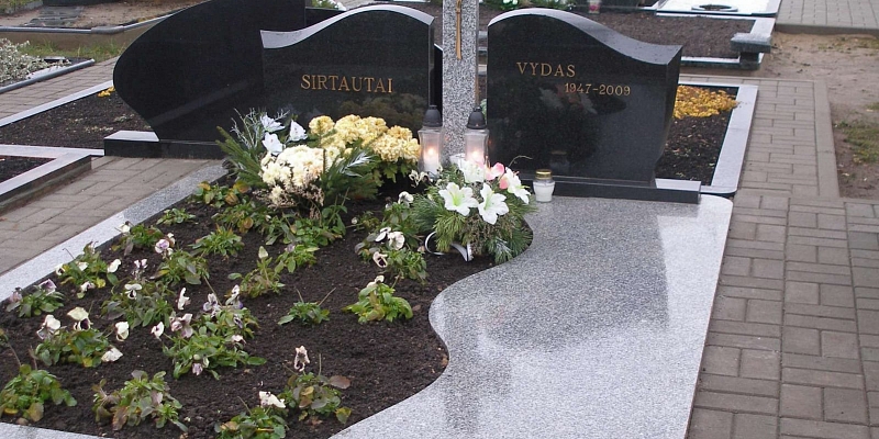 Grave improvement. Tombstone with semi-enclosed granite gravestones with engraving