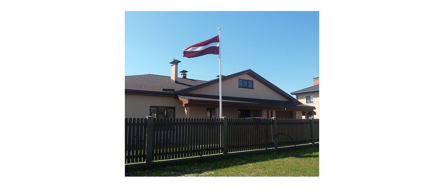 Latvian flag in the yard of a private house